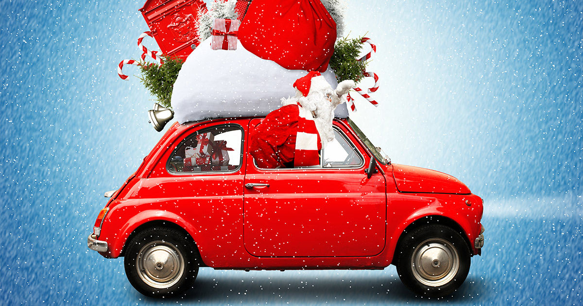 A festive red car overloaded with gifts, a giant Santa sack, candy canes, and a Christmas tree on a snowy day. The scene conveys holiday excitement.